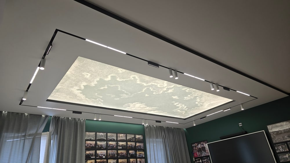 Fertige Spanndecke im Wohnraum: fugenlose Lichtfläche mit schwarzen Lichtlinien